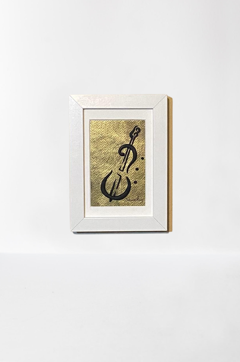 Handmade wall frame, featuring a 3D cello crafted with polymer clay on a golden painted canvas. The frame is white and made of wood.