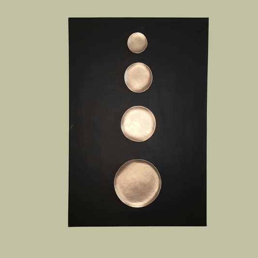 Wall art item containing golden clay asymmetric spheres on wooden canvas